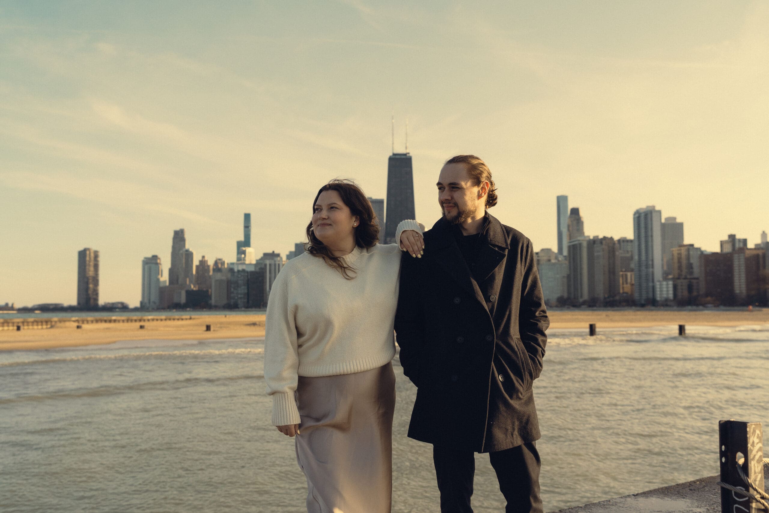 zach and cilla pose on lake michigan for their branding photos